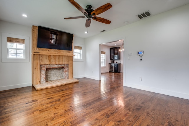 unfurnished living room featuring ceiling fan and dark wood-type flooring