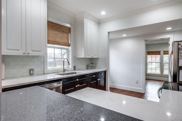 kitchen with white cabinets, tasteful backsplash, and sink