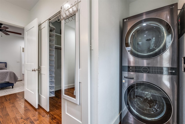 clothes washing area with ceiling fan, stacked washer / drying machine, and dark hardwood / wood-style floors