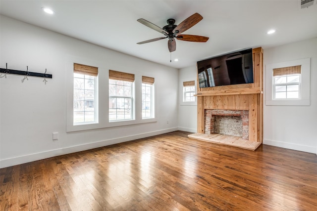 unfurnished living room featuring ceiling fan and hardwood / wood-style flooring