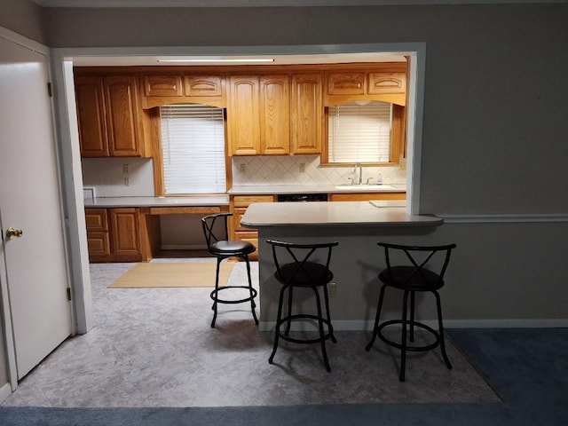 kitchen with sink, a breakfast bar, and decorative backsplash