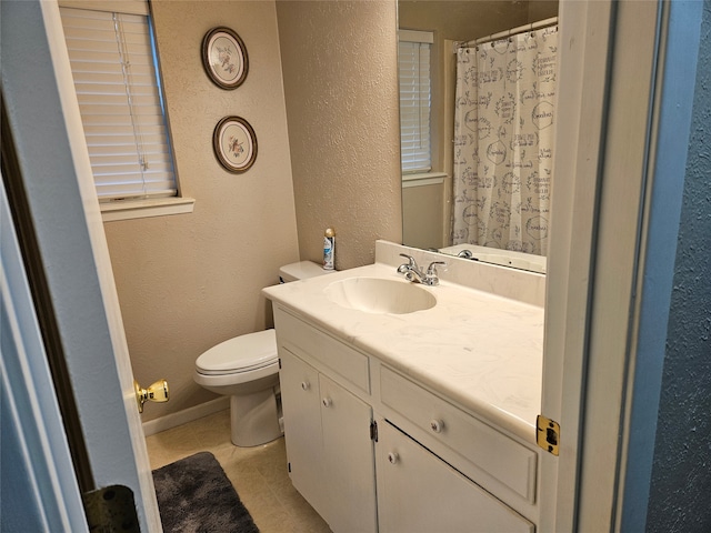 bathroom with toilet, vanity, and tile patterned flooring