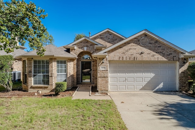 view of front of home featuring a front lawn, a garage, and central AC unit