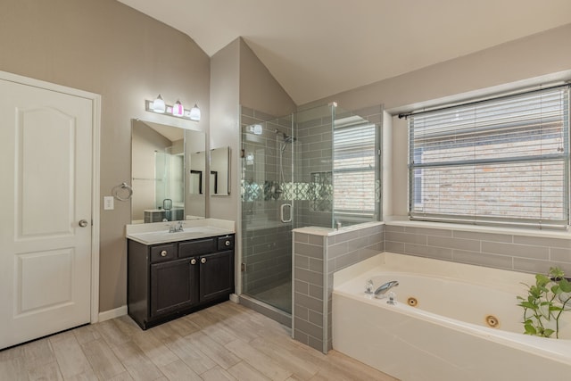 bathroom featuring vanity, independent shower and bath, lofted ceiling, and hardwood / wood-style floors