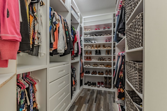 walk in closet with dark hardwood / wood-style flooring