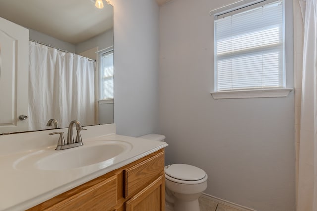 bathroom with tile patterned flooring, vanity, and toilet