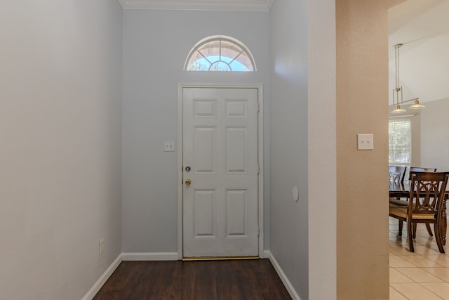 foyer entrance featuring ornamental molding and dark hardwood / wood-style flooring