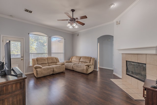 living room featuring hardwood / wood-style flooring, ornamental molding, and a fireplace