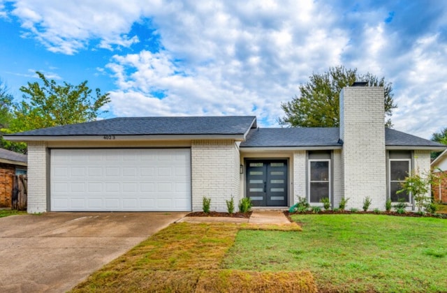 view of front of home with a garage and a front lawn