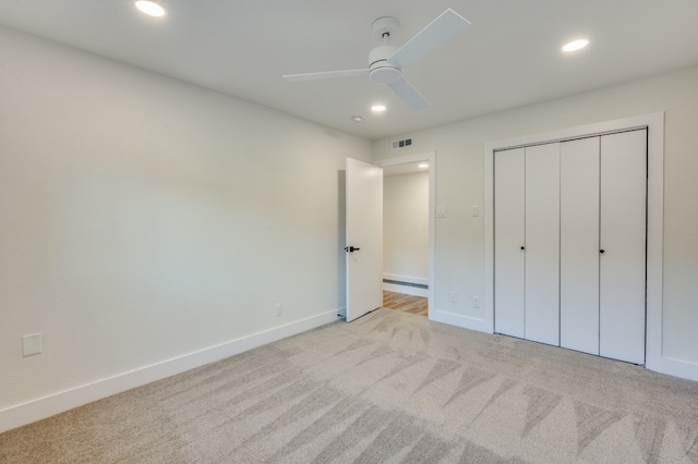 unfurnished bedroom featuring a closet, light carpet, and ceiling fan