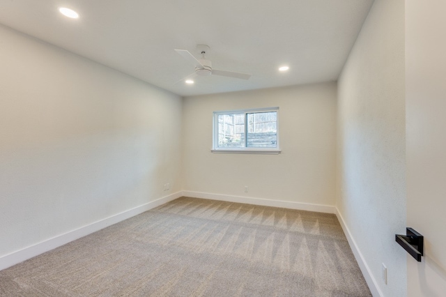 carpeted spare room featuring ceiling fan