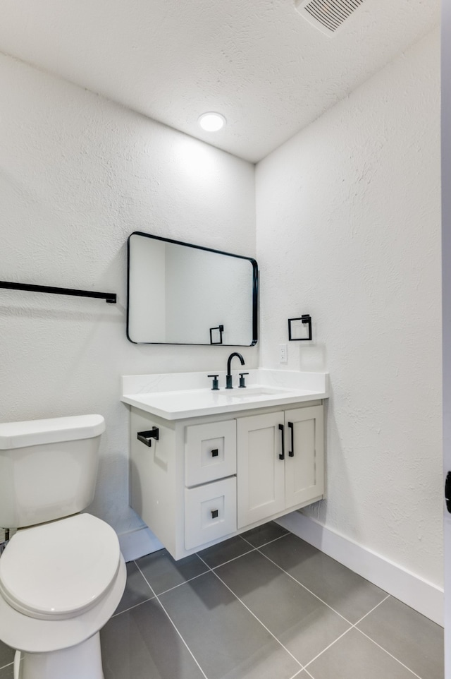 bathroom with vanity, tile patterned flooring, and toilet