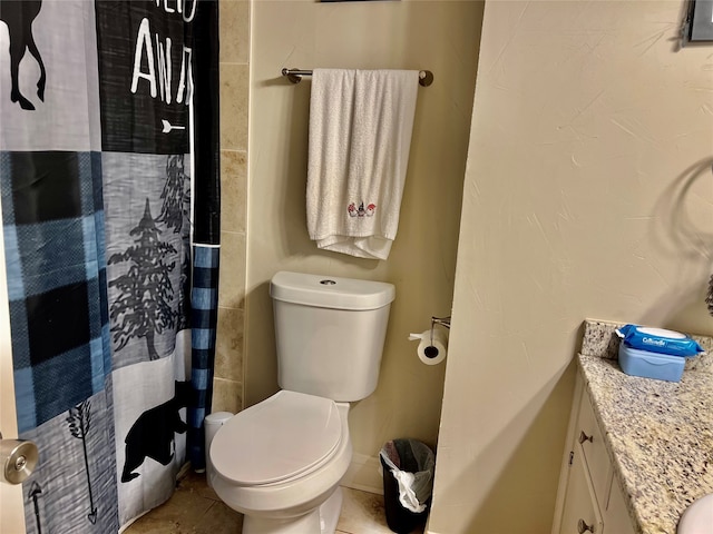 bathroom with toilet, a shower with curtain, vanity, and tile patterned flooring