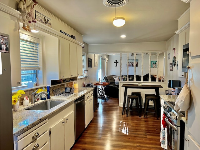 kitchen with dark hardwood / wood-style flooring, light stone counters, sink, white cabinetry, and appliances with stainless steel finishes