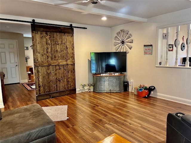 living room featuring a barn door, beam ceiling, and hardwood / wood-style floors