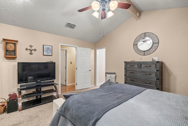 carpeted bedroom with vaulted ceiling with beams, ceiling fan, and a textured ceiling