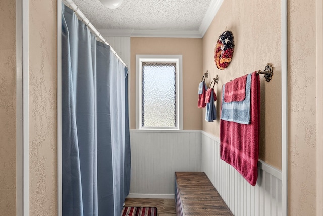 bathroom with a textured ceiling and ornamental molding