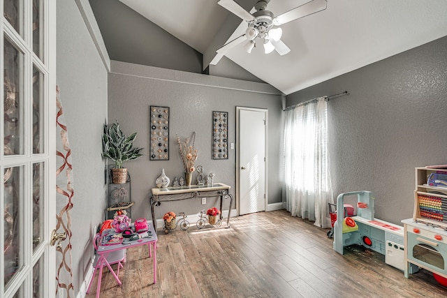 recreation room with hardwood / wood-style flooring, ceiling fan, and vaulted ceiling