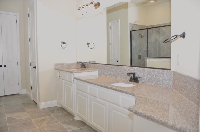 bathroom featuring a shower with shower door and vanity