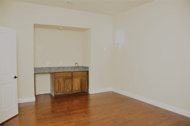 interior space with dark hardwood / wood-style flooring and light stone counters