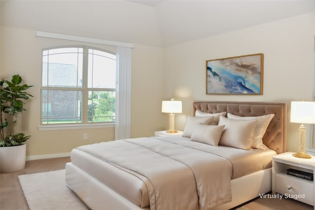 bedroom featuring vaulted ceiling and light carpet