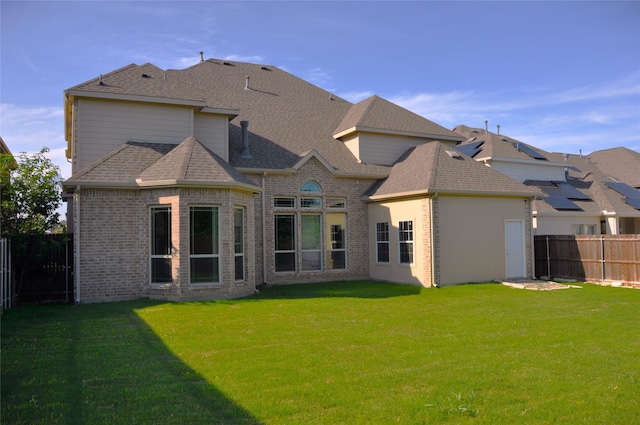 rear view of property featuring a lawn