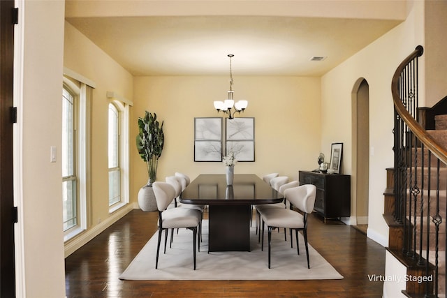 dining area featuring dark hardwood / wood-style flooring and a notable chandelier