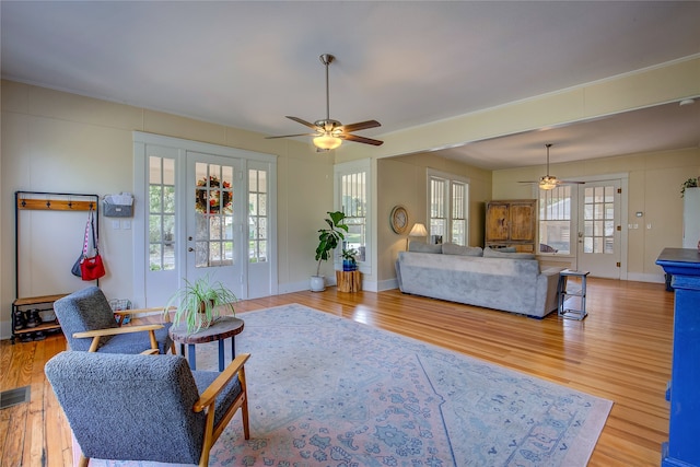 living room with light hardwood / wood-style floors and ceiling fan