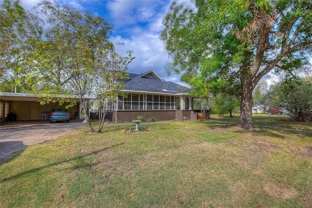 exterior space featuring a sunroom, a carport, and a yard