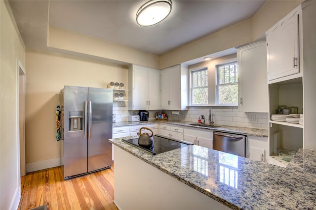 kitchen featuring light wood-type flooring, appliances with stainless steel finishes, light stone countertops, sink, and white cabinets