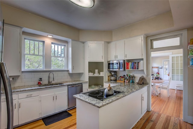 339 N 1st St, Point, TX 75472 - kitchen with stainless steel appliances, a sink, white cabinets, and decorative backsplash