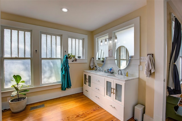 bathroom with backsplash, vanity, and hardwood / wood-style floors