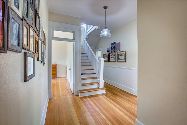 staircase with ornamental molding and wood-type flooring