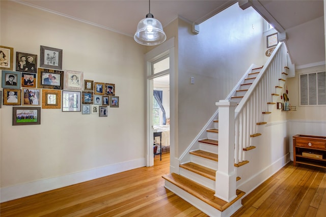 stairway featuring hardwood / wood-style floors and ornamental molding