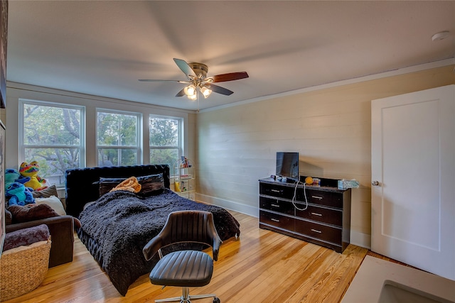 bedroom featuring ornamental molding, light wood-type flooring, and ceiling fan