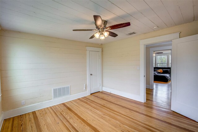 339 N 1st St, Point, TX 75472 - spare room featuring a ceiling fan, light wood-style floors, wooden ceiling, baseboards, and wood walls