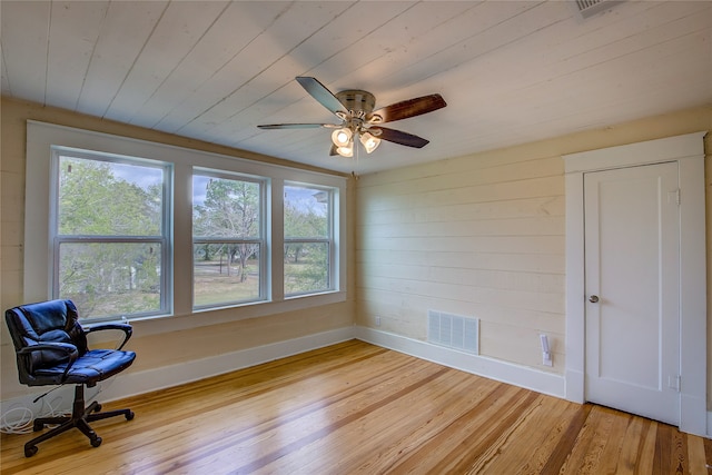 sitting room with light hardwood / wood-style flooring, wood walls, ceiling fan, and wood ceiling