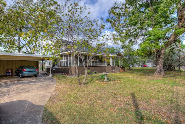 view of front of house with a front lawn, a sunroom, and a carport