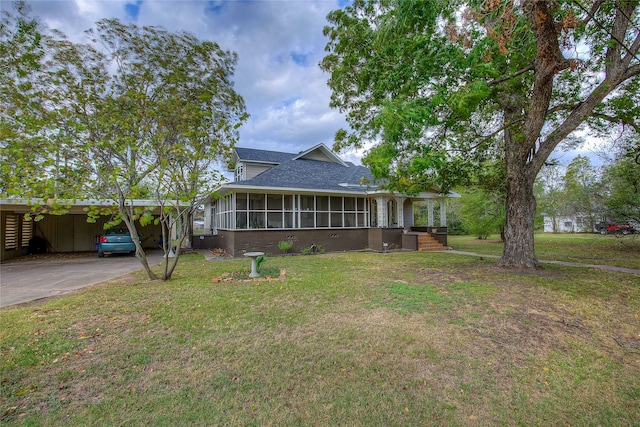 exterior space with a sunroom, a yard, and a carport