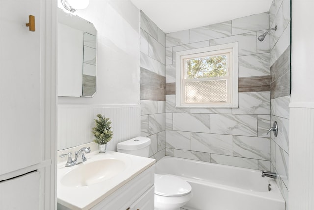 full bathroom featuring vanity, tiled shower / bath combo, and toilet