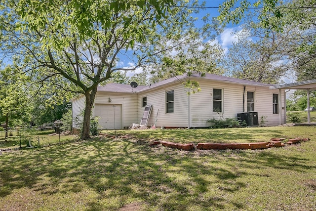 view of front of property with cooling unit, a front yard, and a garage