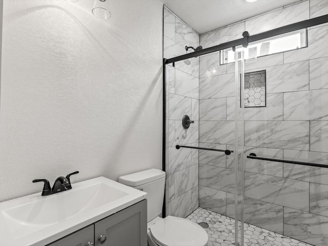 bathroom with a shower with door, vanity, and toilet