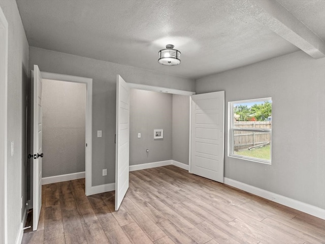 unfurnished bedroom with light wood-type flooring and a textured ceiling