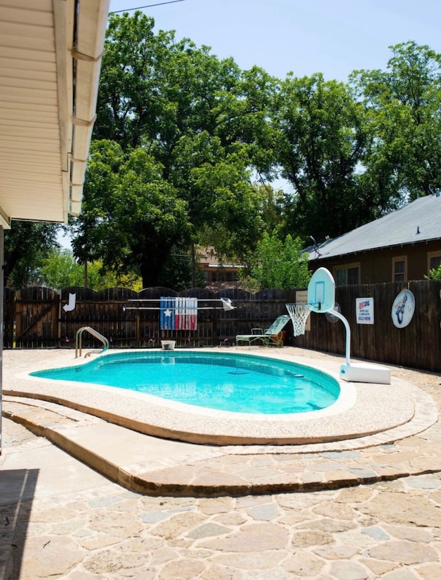 view of pool with a storage shed and a patio