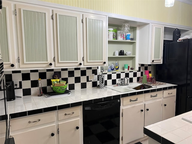 kitchen featuring white cabinetry, tile counters, decorative backsplash, and black appliances