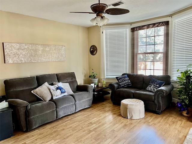 living room featuring a wealth of natural light, ceiling fan, and light hardwood / wood-style flooring