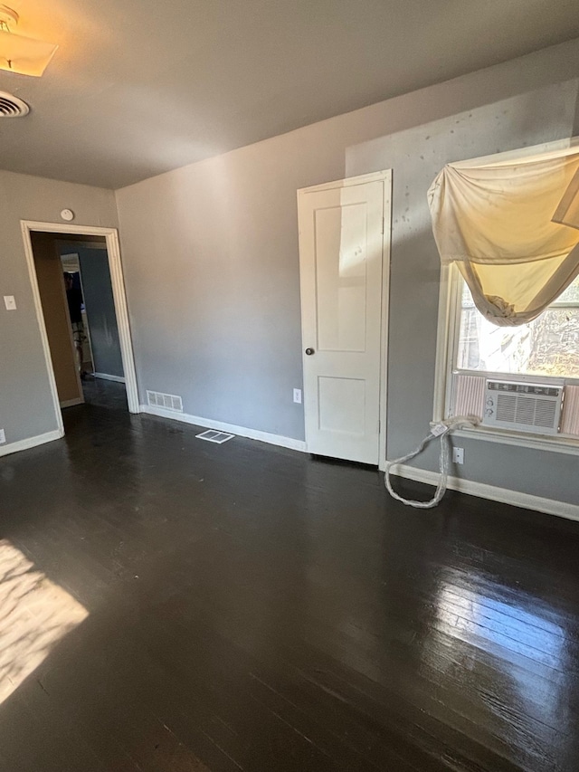 unfurnished room featuring cooling unit and dark hardwood / wood-style floors