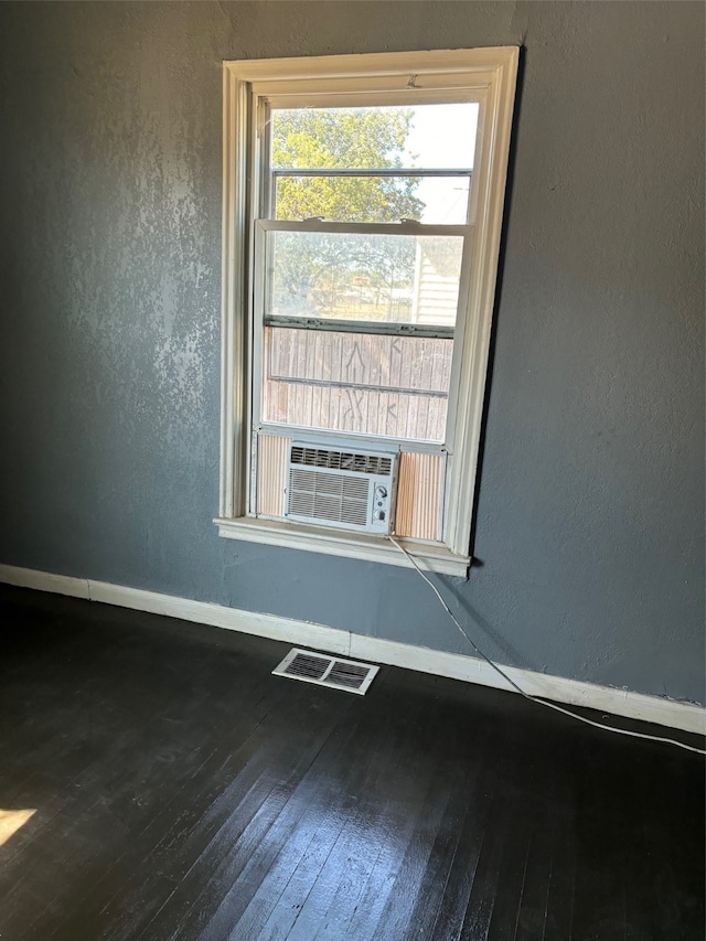 empty room featuring wood-type flooring and cooling unit