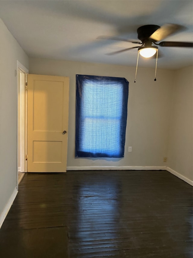 empty room with ceiling fan and dark hardwood / wood-style floors