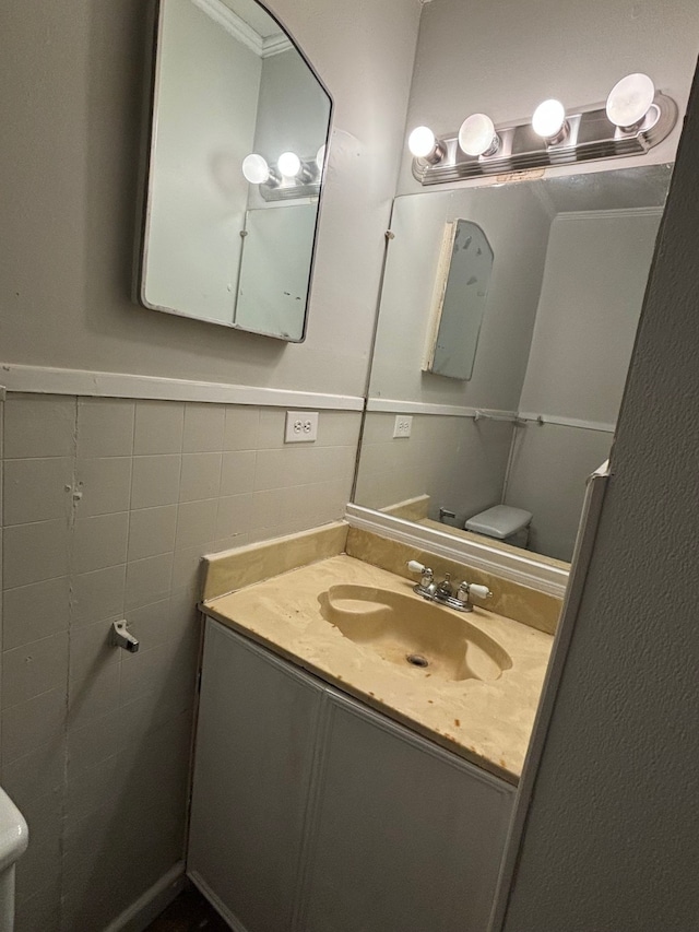 bathroom with tile walls, vanity, and toilet